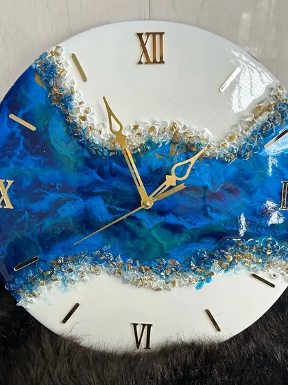 A close-up of a geode-inspired resin wall clock, showcasing the deep blue pigments and sparkling gold crystals. I teach you how to master this popular style, creating a luxurious piece that looks like a slice of natural stone.