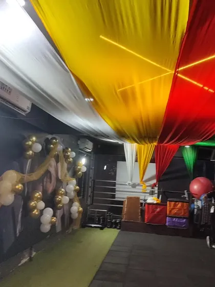 My services extend beyond birthdays to special events like this Dandiya night hosted at a gym. I transformed the space using colorful ceiling drapes and simple gold and white balloon clusters to create a festive atmosphere without getting in the way.