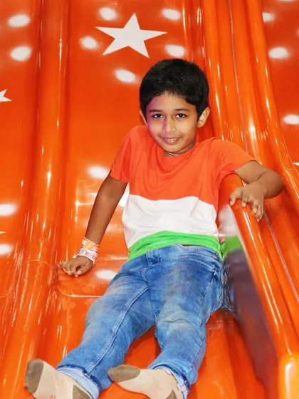 Dressed in the colors of the flag, a boy enjoys our bright orange slide. The entire play area gets a festive makeover during our national holiday celebrations.