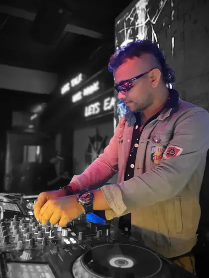 A stylized shot of me deep in the mix, with a focus on my hands on the Pioneer DJ controller. This highlights the technical side of my performance.