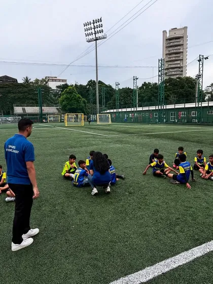 A wide shot of the sports psychology session on the turf.