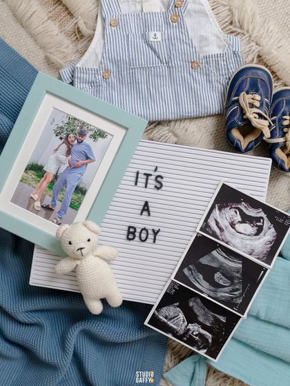 A beautifully styled flat-lay announcing "It's a Boy," featuring sonogram pictures, a framed photo, and tiny baby clothes. It's a thoughtful and aesthetic way to share the news.