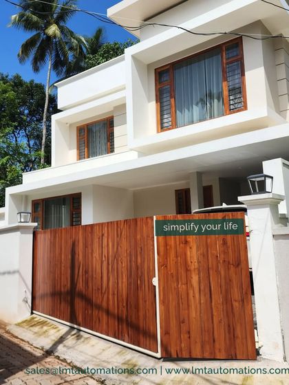 A beautiful trackless sliding gate with a wooden finish, perfectly complementing this modern home's architecture. The cantilever system allows for a clean, uninterrupted driveway.