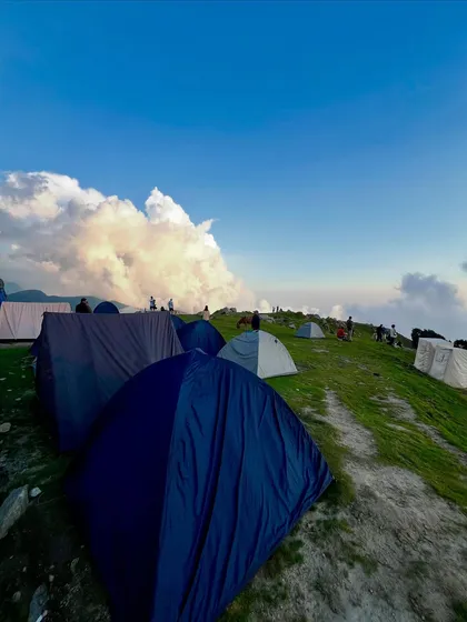 Our campsite at Triund, with tents pitched on the green ridge, ready for a night under a blanket of stars.