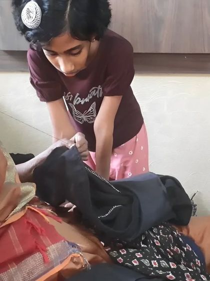A young girl learns about mending from an elder, a beautiful moment of knowledge transfer between generations. Our workshops bring people of all ages together.