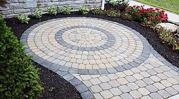 I can create detailed patterns to make a patio or walkway unique. This circular paver design adds a nice custom touch and serves as a focal point for the entrance area.