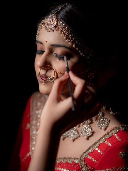 An artistic, unfiltered shot of the eye makeup application, capturing the process in a dramatic way.