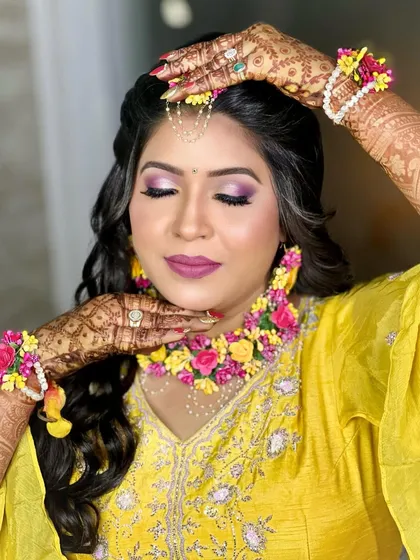 A creative pose showing the intricate floral hathphool and the beautiful mehndi design on her hands.