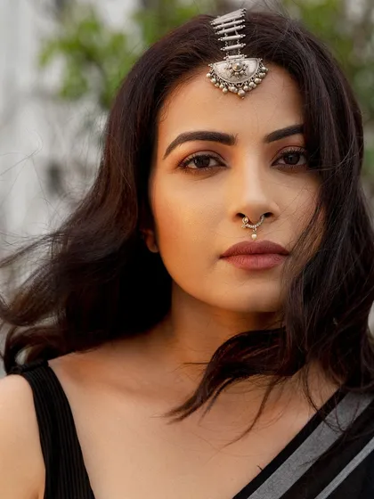 A powerful close-up where the focus is entirely on the expression. The traditional silver jewelry adds a layer of character, but the direct gaze is what holds the attention, making it an ideal headshot for an actor.