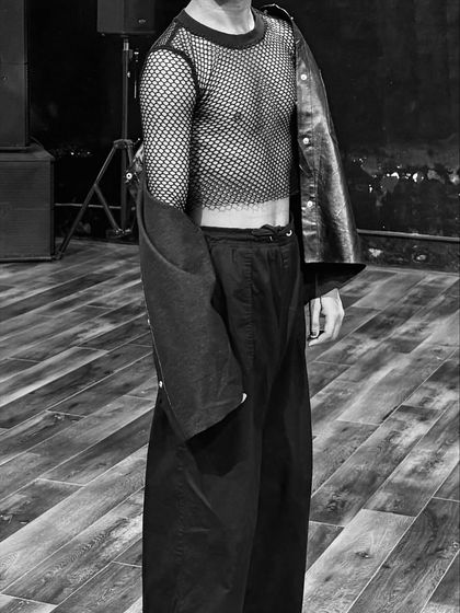 A black and white shot focusing on the texture and style of my outfit, featuring a mesh top and leather jacket.