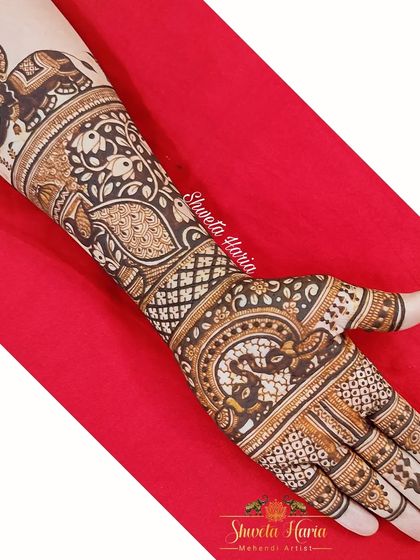 A heavy Indian design featuring a royal elephant with an umbrella, a classic symbol of grandeur. The arm is covered in intricate paisley and floral patterns, creating a truly majestic look.