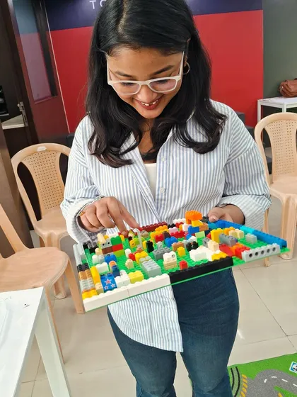 A participant proudly shows off the intricate LEGO city she built. We love seeing the detailed and imaginative creations that come out of our building workshops.