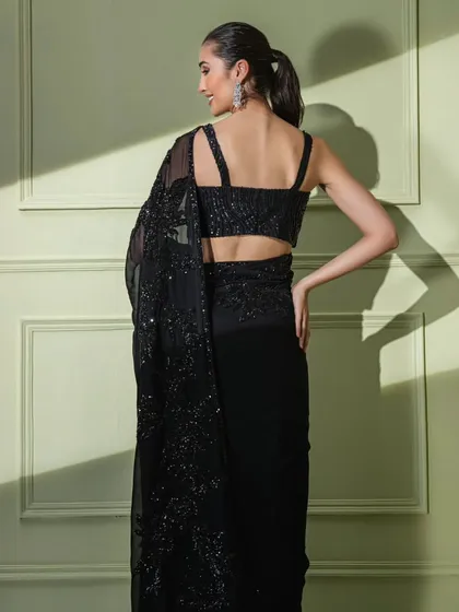 The back of the classic black floral embroidered saree, featuring a modern strappy blouse design.