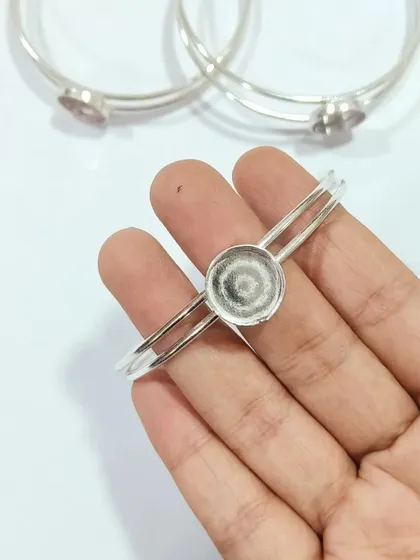 This adjustable brass bracelet kada features a round bezel perfect for your resin art. It's shown here in a sleek silver finish, offering a modern and elegant base for creating custom resin bracelets.