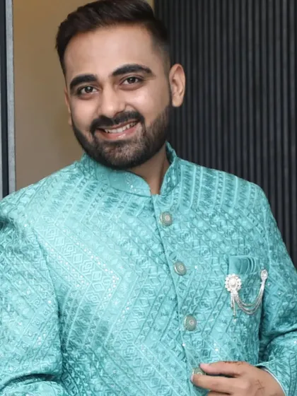 The groom looking sharp in his turquoise wedding outfit. The makeup is balanced to complement the bright color of his attire.