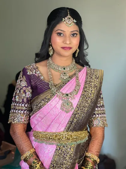 A beautiful portrait of the bride in her reception attire. The half-up hairstyle keeps the hair off her face to showcase the stunning jewellery and makeup.