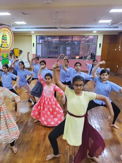 A group of young girls striking a powerful Chhau pose. Our classes aim to empower students, building their confidence and physical strength.