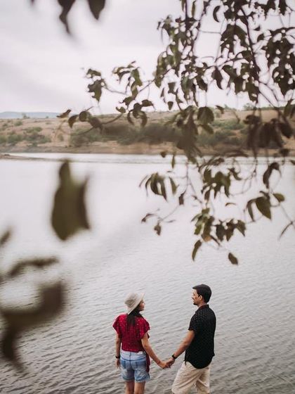 Another view of the couple by the water, framed by leaves. This technique creates a sense of peeking in on a private, intimate moment.