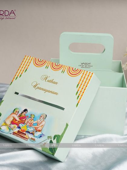 A unique and practical invitation box for an Upanayanam ceremony. The mint green box features a convenient handle and a custom illustration on the lid, with space inside for the invitation and other keepsakes.