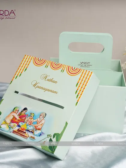 A unique and practical invitation box for an Upanayanam ceremony. The mint green box features a convenient handle and a custom illustration on the lid, with space inside for the invitation and other keepsakes.
