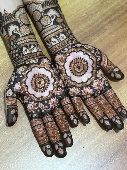 A stunning design with large floral mandalas on the palms, surrounded by peacock and architectural motifs on the arms.