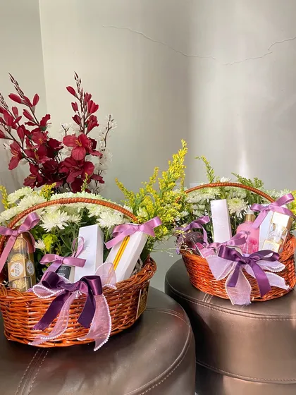 Because every celebration deserves something special. These wicker baskets are filled with flowers, chocolates, and other gifts, tied with a beautiful purple ribbon for a classic and elegant look.
