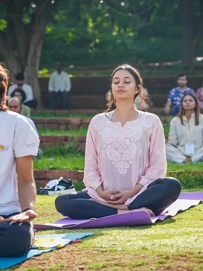 Finding a moment of peace is easy here. This shows a group meditation session on the lawn, a common sight where guests and residents alike connect with the tranquility of the campus.
