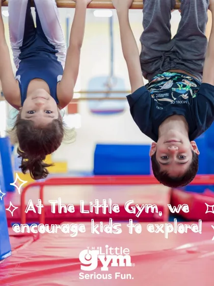 Two children hang upside down from the bars, smiling for the camera. This playful exploration builds significant upper body and grip strength, while also improving spatial awareness and confidence.