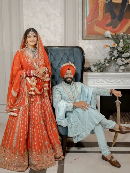 We specialize in creating regal portraits that feel both classic and natural. This shot of Vanaja and Angad showcases their royal poise, with the bride in a stunning red lehenga and the groom in a powder blue sherwani, seated in a composition of pure elegance.