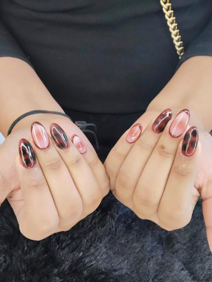 A chic and trendy tortoiseshell nail art design. The warm brown and black pattern on a sheer base creates a sophisticated and timeless look.