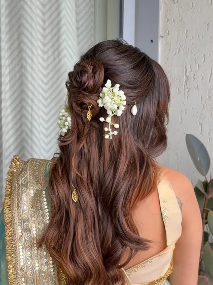 Celebrating a mother-to-be with a soft and beautiful hairstyle is always special. This half-updo features a delicate floral bun and cascading waves, perfect for a baby shower.