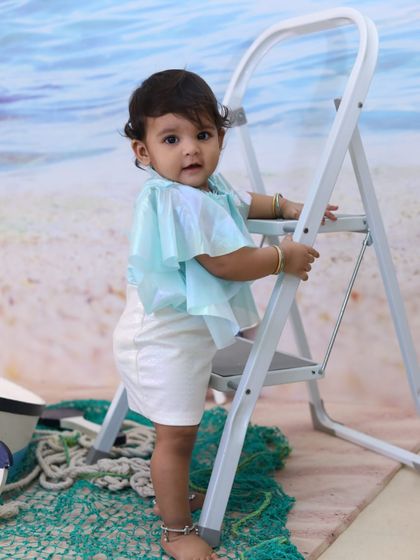 Explore our full nautical and beach-themed collection. These images showcase the variety of poses and angles possible with our boat prop, sand-colored flooring, and ocean backdrop.