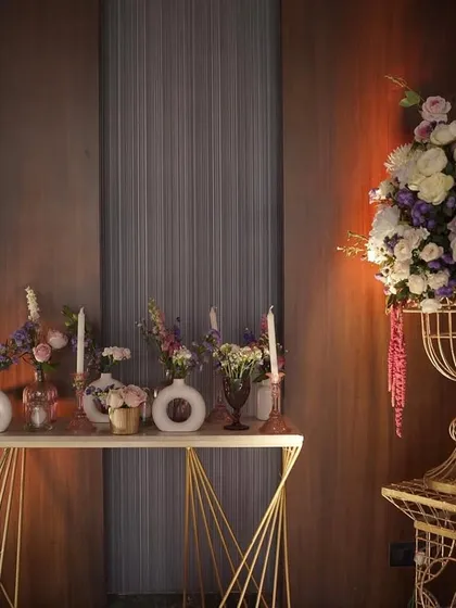 A console table decorated with an array of flowers in modern vases, showing a blend of contemporary style with a romantic floral palette.