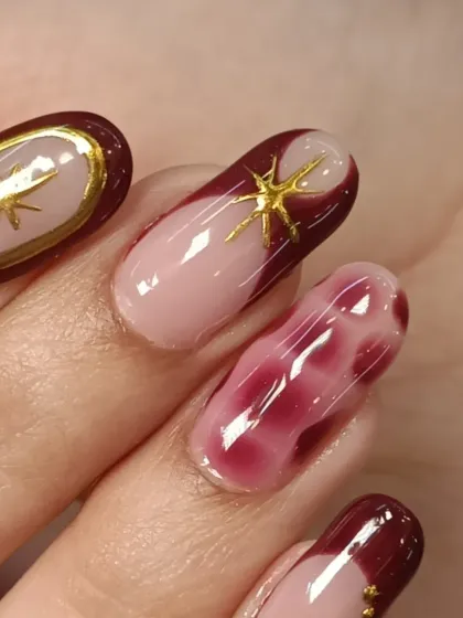 A closer look at the maroon and nude nail set. You can see the detail in the gold star charm and the beautiful, cloudy effect of the blooming gel nail.