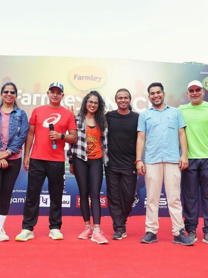 On stage with the microphone, addressing the crowd alongside my team at the Farmley Snack Run. Clear communication and high energy are key to our events.