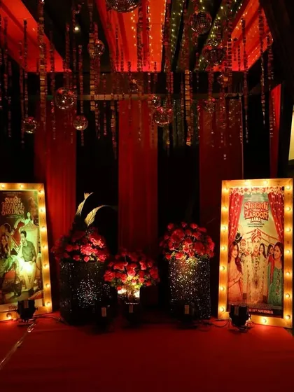 A photo corner at the Bollywood-themed sangeet, featuring vintage movie posters of the couple and dramatic red and black draping. It’s a fun and interactive spot for guests to take pictures.
