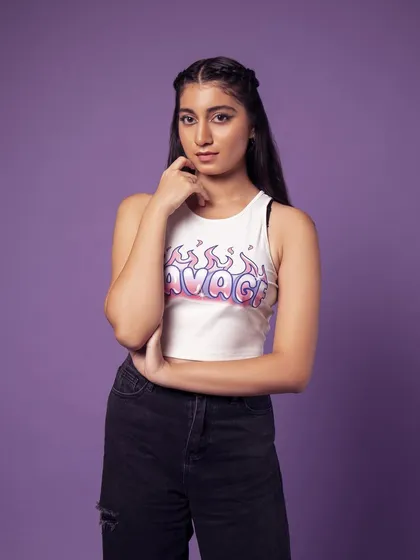 A three-quarter shot showing the full top and jeans. The pose is casual and confident.