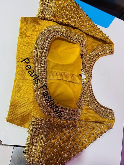 This is the front view of a heavy bridal blouse. You can see the padded construction for a good fit and the dense bead and stonework covering the neckline and sleeves.