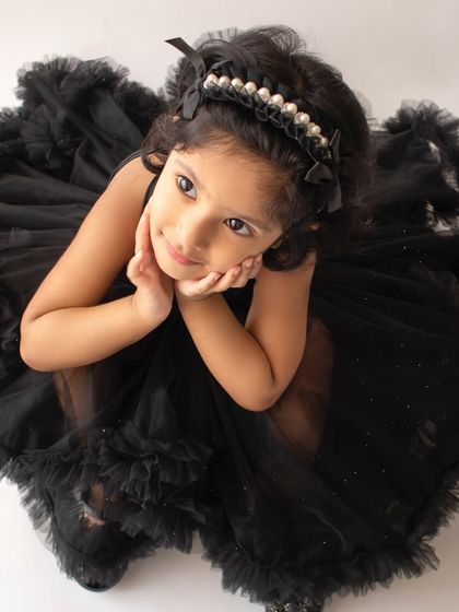 An overhead shot that highlights her thoughtful expression and the beautiful details of her pearl headband and dress.