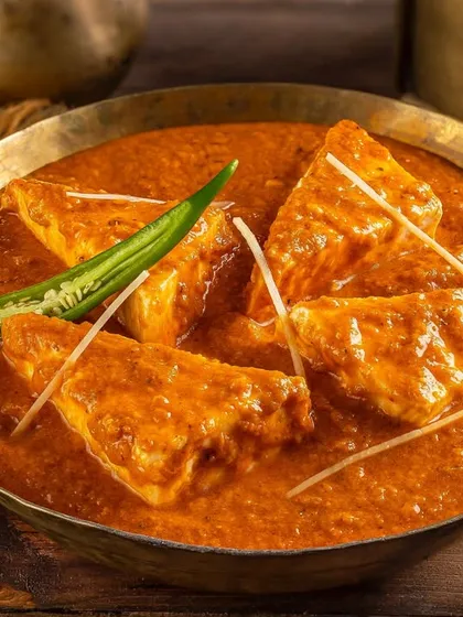 A rich and creamy paneer curry for Nazeer Foods, presented in a traditional brass bowl.