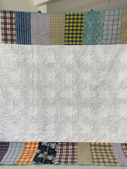 The back of the shirt quilt, cleverly pieced together from the remaining shirt fabric.