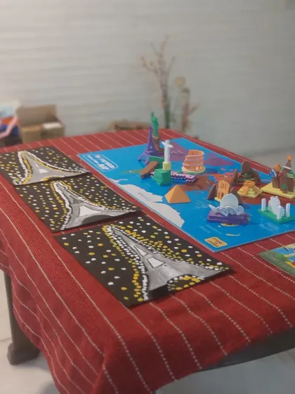 The setup for our 'Wonders of the World' session, with a world map, monument models, and the beautiful finished Eiffel Tower paintings.