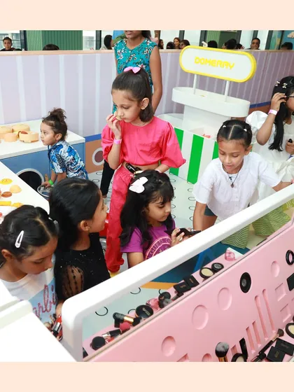 A whole group of friends gathered at the makeup station, a very popular spot during birthday parties.