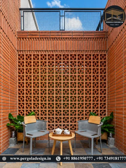 A cozy outdoor seating nook created with terracotta jali brick walls. The perforated design allows for ventilation and light while offering a sense of enclosure and privacy, perfect for a small courtyard or balcony.