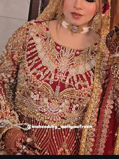 Another shot of the bride, showing how the detailed mehendi complements her beautiful bridal outfit.