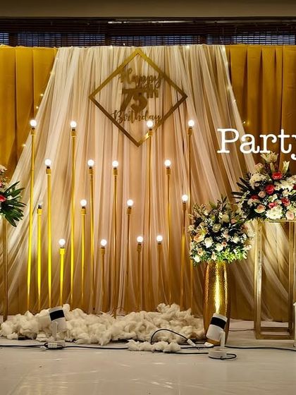 Another perspective of the golden-themed stage, highlighting the beautiful interplay of light, fabric, and flowers.