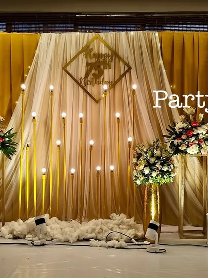 Another perspective of the golden-themed stage, highlighting the beautiful interplay of light, fabric, and flowers.
