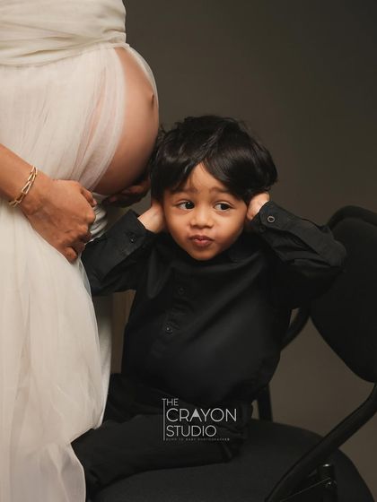 A playful and honest moment from a soon-to-be big brother. Listening to his mom's belly, his expression is priceless. These are the funny, real moments that tell the true story of your family.