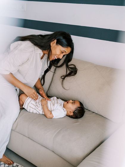 A nine-month-old baby laughing as his mother tickles him. The beautiful natural light in their home made this indoor session feel magical.