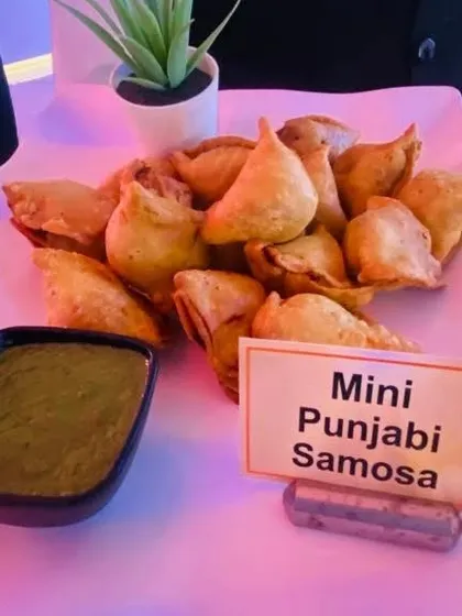 A classic snack, perfected. Our Mini Punjabi Samosas are crispy, flaky, and filled with a savory potato and pea mixture, served with a fresh mint-coriander chutney.